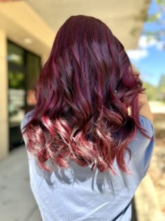 Long burgundy-red hair with loose waves.